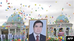 Участники шествия в честь празднования Дня независимости Туркменистана несут портрет президента Гурбангулы Бердымухамедова. Ашгабад, 27 октября 2009 года.