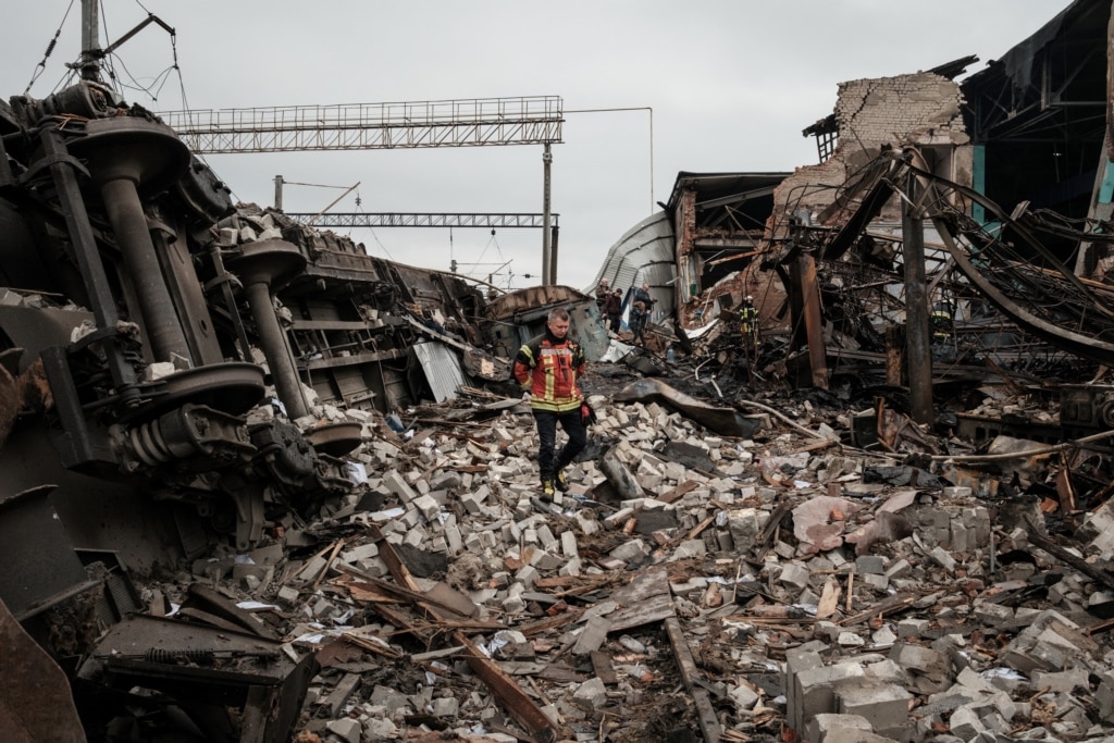 A firefighter walks through rubble at a freight railway station in Kharkiv, which was partially destroyed by a Russian strike.