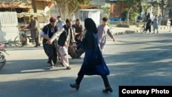 تعدادی از مردم جسد یکی از قربانیان رویداد کاج را منتقل می کنند