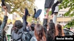 Iranian students remove their headscarves in support of protests following the death of Mahsa Amini.
