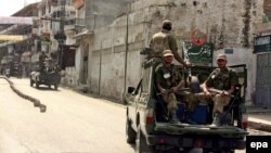 FILE: Pakistani army soldiers enforce curfew in the northwestern Swat Valley in 2009.