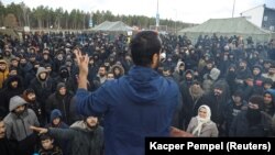 Migranți adunați în tabăra de la Bruzgi, improvizată de autoritățile belaruse în apropiere de granița cu Polonia, în regiunea Grodno, 20 noiembrie 2021. 