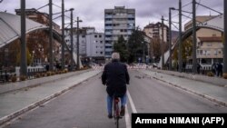 Një burrë duke ngarë biçikletën mbi urën e Ibrit, ndërmjet Mitrovicës së Jugut dhe Mitrovicës së Veriut. Fotografi nga arkivi.