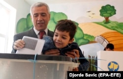 Oliver Ivanovic casts his vote in local elections along with his son at a polling station in northern Mitrovica in October.