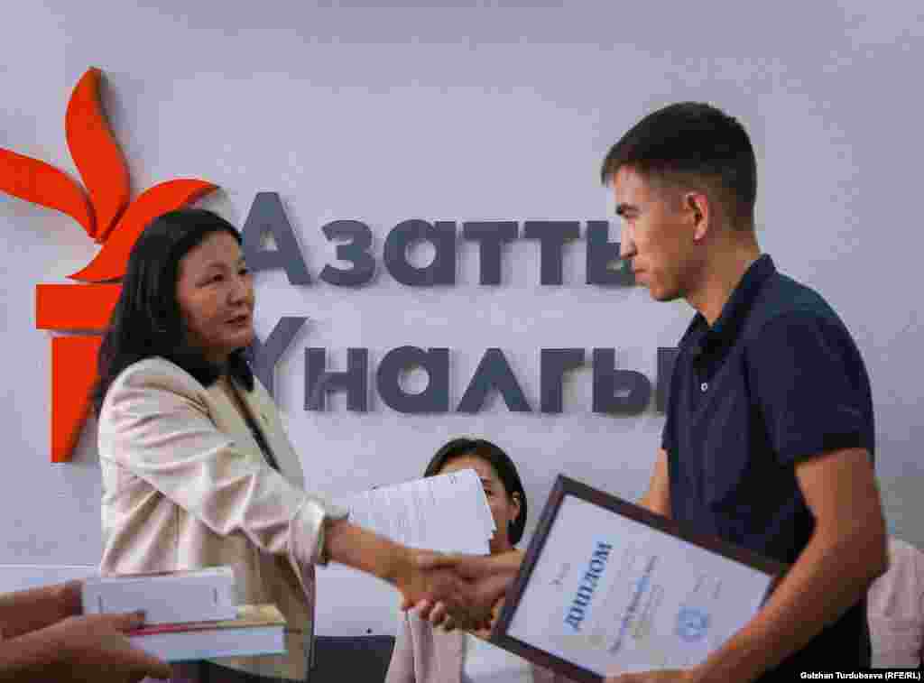 "Эркин Европа/Азаттык" радиосунун кыргыз кызматынын директору Венера Жуматаева сынактын жеңүүчүлөрүнө сыйлык тапшырууда.&nbsp;