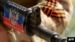 Украина. Вооруженный мужчина в военной форме держит автомат с изображением флага самоназванной «Донецкой Народной Республики», охраняя здание Службы безопасности (СБУ), захваченное сепаратистами в Славянске. 28 апреля 2014 года. 