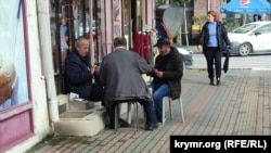 Чоловіки грають у карти біля магазину на вулиці Пушкіна