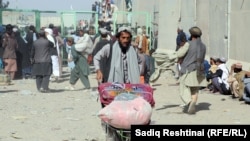 د چمن او سپین بولدک پر پوله یو مزدور په لاس ګاډۍ کې د مساپرو سامان وړي ـ پخوانی انځور.