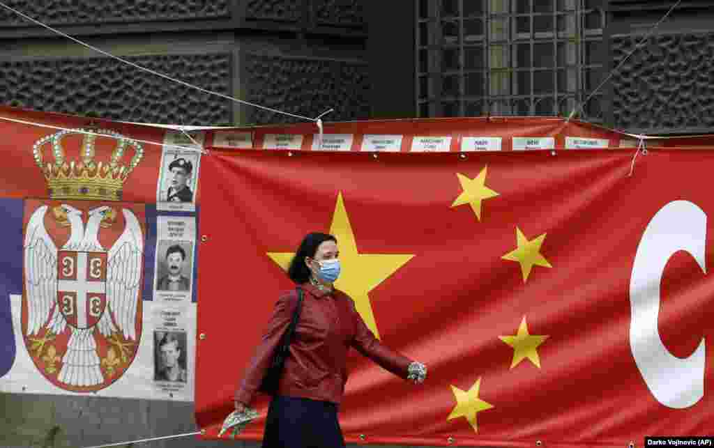 A woman walks past giant banners linking Chinese and Serbian flags in Belgrade. &nbsp; Zoric says both China and Russia are &ldquo;very present&rdquo; in Serbia and such signage may be a way of hinting to the EU that the country has options for geopolitical alignment. &ldquo;I think Serbia is trying to make the EU jealous a little bit. Otherwise, we could open ourselves to Russia and China.&rdquo;