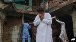 د بونېر یو اوسېدونکی په سېلاب کې د خپل ړنګ کور مخې ته ژاړي - د اګست ۱۷مې انځور.