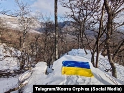 Украинский флаг на горе Басман. Одна из акций движения «Желтая лента» в марте 2025 года