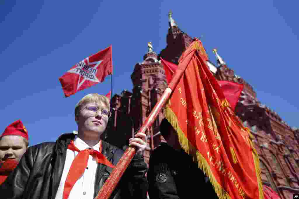 A boy holding a communist-style flag on Red Square.&nbsp; Critics of the Kremlin say the current move to revive state-organized youth movements is aimed, in the long term, at raising "a new generation of soldiers."