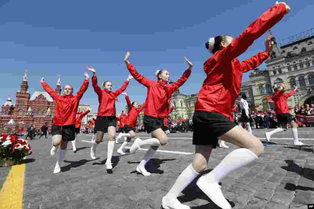 Girls in red neckerchiefs dance on Red Square. The Moscow ceremony was staged to mark the 100th anniversary of the founding of the Young Pioneers organization.