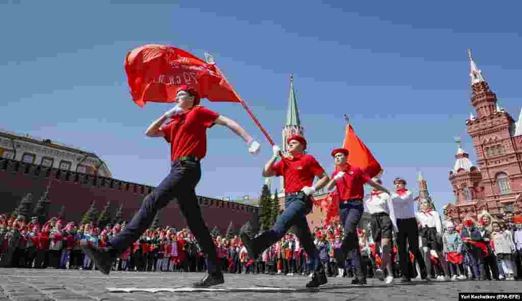 Russian children march under a flag featuring the communist hammer and sickle on Moscow&rsquo;s Red Square on May 22. Some 5,000 schoolchildren became &ldquo;All-Russian Pioneers&rdquo; during a ceremony organized by the country's Communist Party on May 22, replete with symbology from Russia&rsquo;s socialist past.