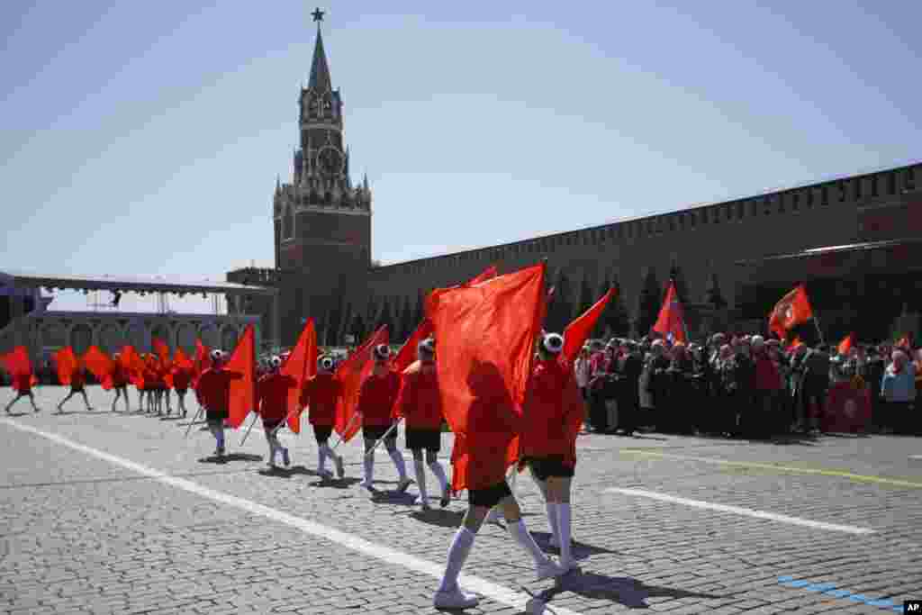 Children march with blank red flags in front of the Kremlin's Spassky Tower.&nbsp; The Communist Party initiative comes as children in schools across Russia have been coerced into showing "support" for the invasion of Ukraine, often without the knowledge of parents.