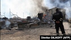 (Një polic i Kosovës duke shikuar djegien e pikës kufitare në Bërnjak në vitin 2008, AFP)