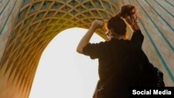 Një grua duke ecur pa hixhab në sheshin Azadi në Teheran, në janar.