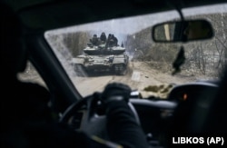 Український танк із військовими видно через вікно автомобіля неподалік від лінії фронту біля Кремінної Луганської області