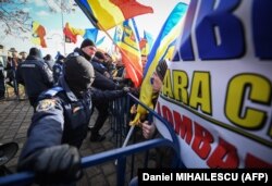 Atmosfera dintre protestatari și jandarmi a fost una tensionată de la bun început. Forțele de ordine nu au intervenit nici după ce protestatarii au dărâmat ușa de la intrarea în curtea Senatului.