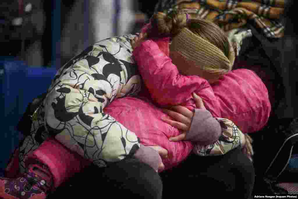 O mamă își duce copilul în brațe, la scurt timp după ce a intrat în România pe la Isaccea, județul Tulcea. Imagine din 1 martie 2022. Un tir cu alimente din România urmează să ajungă la Izmail pentru a ajuta populația ucraineană.&nbsp; &nbsp;