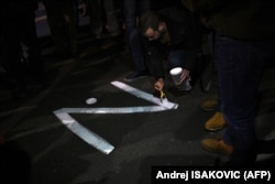 Një protestues në Serbi vizaton simbolin 'Z' në një rrugë të Beogradit.