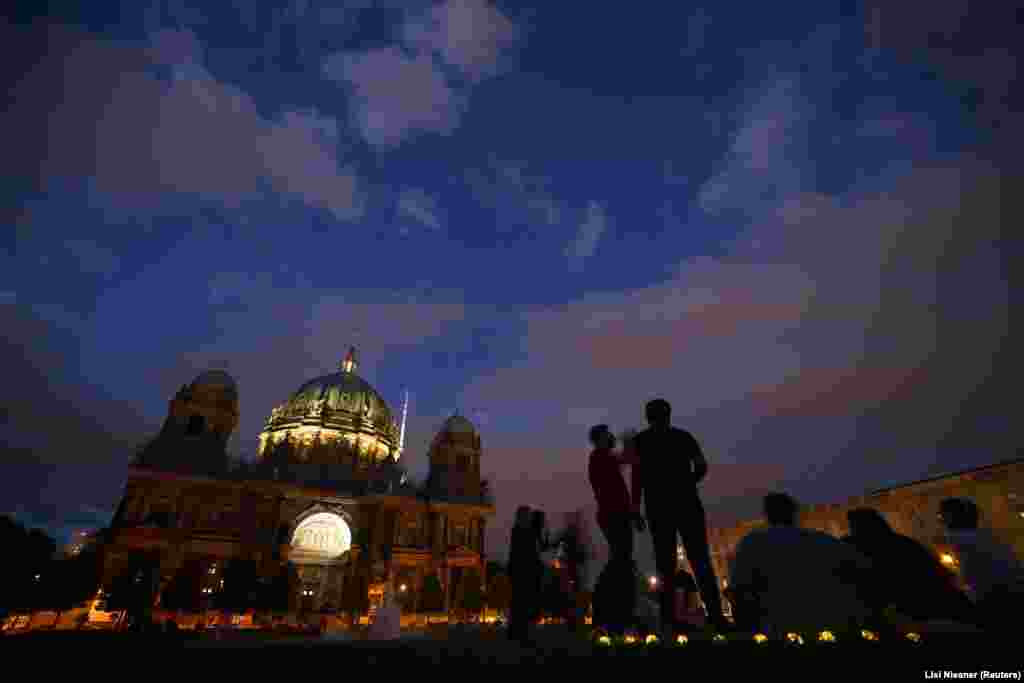 In Berlin too, historic sites stand largely unlit after sunset. People enjoy a summer evening next to Berlin's central cathedral.&nbsp; &nbsp;