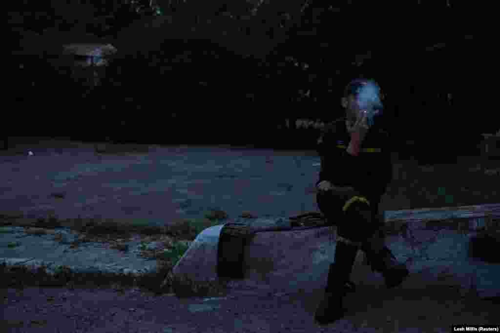 Пожежник Сергій курить, поки поруч із ним сохне бронежилет, Харків, 29 червня 2022 року. Як повідомив прес-офіцер ГУ ДСНС України у Харківській області Євген Василенко, вогнеборцям доводиться гасити пожежі під час обстрілів. Задля їхньої безпеки, вони зараз носять шоломи та бронежилети, які додають близько 20 кг ваги до їхнього звичного спорядження