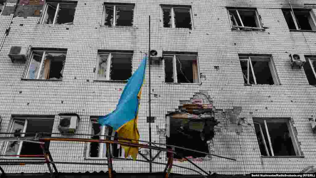 Прапор України на обстріляній цивільній будівлі у центрі Мар'їнки. Донбас, серединіа&nbsp; квітня 2022 року. Російські війська, покинувши під тиском ЗСУ північ України, посилили атаки на Донбасі.&nbsp; Боротьба за український прапор над визнаними світом українськими землями&nbsp;&ndash; триває