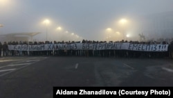 Республика алаңында "Қарапайым халықпыз. Біз — террорист емеспіз!" деген жазу ұстап тұрған адамдар. Алматы, 6 қаңтар 2022 жыл.