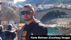 "Radijus kretanja nam je bio 200 metara", sjeća se Haris Behram svog odrastanja u razorenom ratnom Mostaru. Iza njega, na ovoj nedavnoj fotografiji, pruža se pogled na most obnovljen nakon rata, pošto je poznati mostarski Stari most uništen u granatiranju 1993. godine.