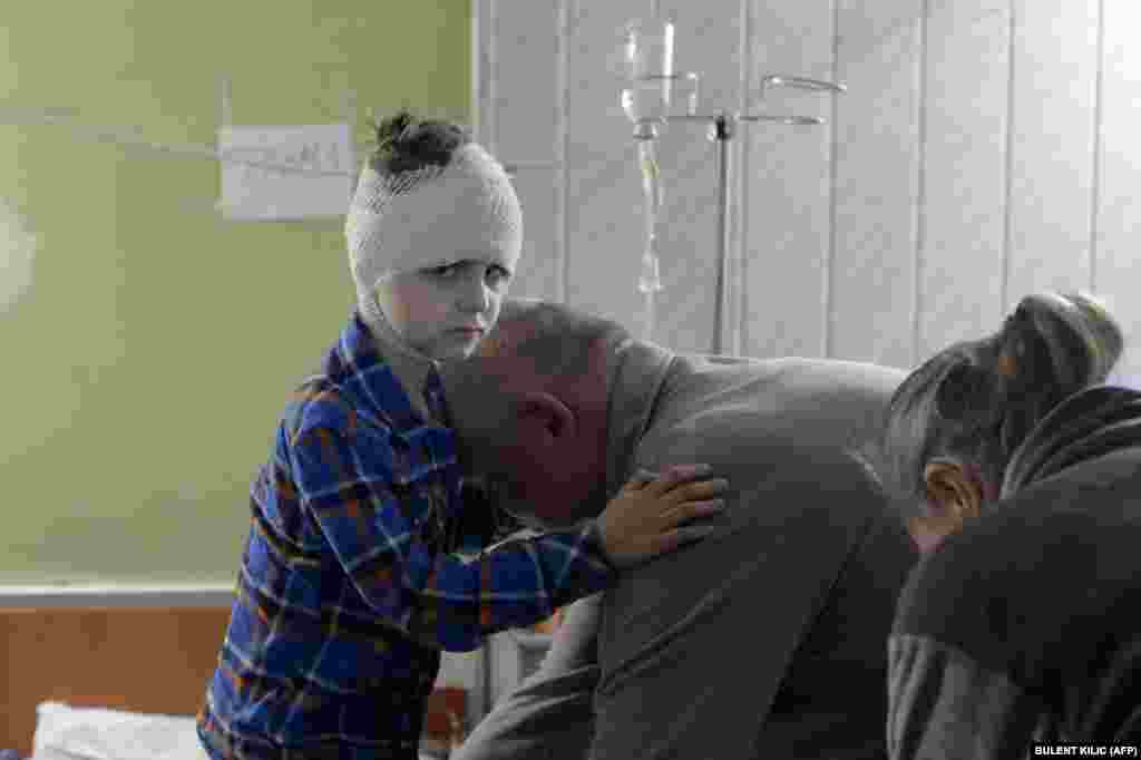 Mișa, în vârstă de 5 ani, este ajutat de bunicul său, pe 28 martie, să se îmbrace la un spital din orașul Mikolaiv situat în sudul Ucrainei. Mișa a fost rănit în timpul unui atac aerian rusesc. &nbsp;