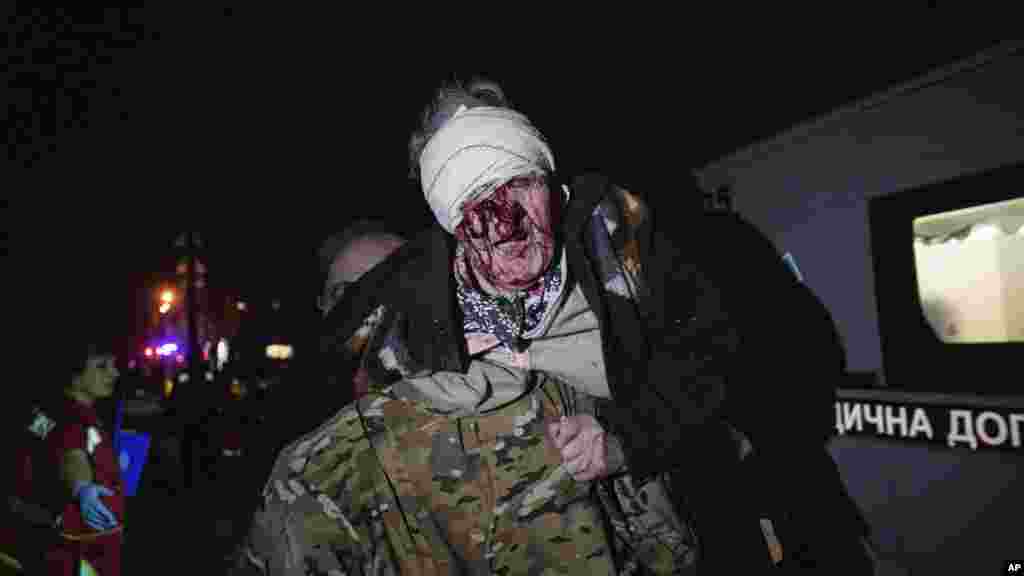 24 aprilie 2025, Kiev, Ucraina – Un soldat ucrainean scoate o femeie rănită din casa ei, lovită de atacul rusesc asupra capitalei ucrainene.