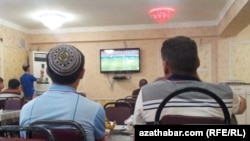 Aşgabatda telewideniýä tomaşa edýän ýaşlar.