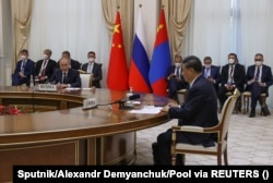 Си Цзиньпин (справа на первом плане) и Владимир Путин (слева на первом плане) на встрече на полях саммита Шанхайской организации сотрудничества в Узбекистане в сентябре