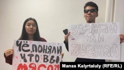 Белсенді жастар Қарагөз Қасым мен Айсұлтан Құдайберген әуежайдың полиция бөлімінде пикет өткізуге әкелген плакаттарын ұстап тұр. Алматы, 23 қыркүйек 2022 жыл.