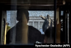 საპროტესტო აქციის მონაწილე ლენინის ქანდაკებასთან ბიშკეკში 2021 წელს