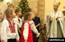 Діти біля чоловіка в образі святого Миколая під час урочистого відкриття святкової програми для дітей «Чудеса від святого Миколая». Київ, 16 грудня 2016 року