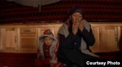 Тарбагатайлык аял темир ооз комуз чертүүдө. («Youku» сайтындагы видеотасмадан алынган сүрөт)