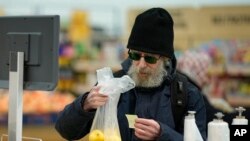 Покупатель взвешивает фрукты в супермаркете в Москве