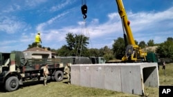 Romanian Army engineers install concrete shelters in the village of Plauru on the Danube River border between Romania and Ukraine on September 12, 2023.