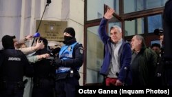 Кэлін Джарджэску з паднятай рукой пасьля допыту 26 лютага 2025