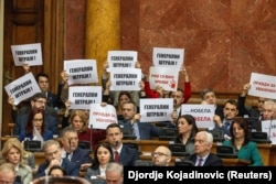 Përfaqësues të opozitës serbe me mesazhe mbështetëse për lëvizjen studentore gjatë seancës së Kuvendit serb, më 4 mars 2025.
