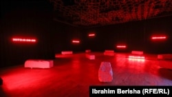 Fotografi nga një instalacion artistik me gurë dhe orë ku gurët simbolizojnë varrin e munguar të të pagjeturve ng alufta në Kosovë, kurse ora simbolizon kohën e kaluar që nga zhdukja e atyre personave.