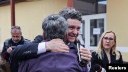 Nicușor Dan, îmbrățișând un alegător la secția unde a votat, în Făgăraș, deschisă chiar în școala unde și-a făcut studiile