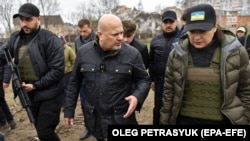 Прокурор Міжнародного кримінального суду (МКС) Карім Хан (посередині) та генеральний прокурор України Ірина Венедіктова відвідали місце братської могили в місті Буча під Києвом, 13 квітня 2022 року