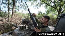 Un soldat de artilerie ucrainean, conducând un Howitzer 2S3 Akatsiya în regiunea Nikolaiev din sudul Ucrainei, 19 septembrie 2022.