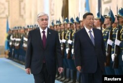 Президент Казахстана Касым-Жомарт Токаев и председатель КНР Си Цзиньпин проходят мимо почетного караула перед их переговорами в Астане, 3 июля 2024 года