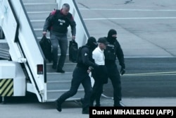 Vladimir Plahotniuc este escortat de mascați din avionul cu care a fost adus la Chișinău, 25 septembrie 2025.