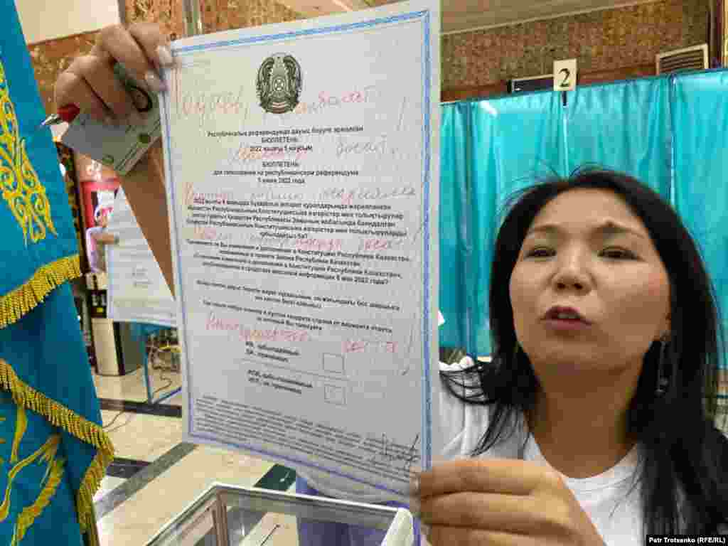 Белсенді Инга Иманбай №253 референдум учаскесінде "Тоқаев, Жанболат Мамайды босат! Қаңтар тізімін жарияла! Саяси тұтқындарды босат! Назарбаевты сотта!" деген талаптар жазылған бюллетеньді көрсетіп тұр. Алматы, 5 маусым 2022 жыл.