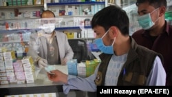 FILE: Afghans buy protective masks after first positive case of coronavirus was reported near the Iranian border in the western city of Herat in February.